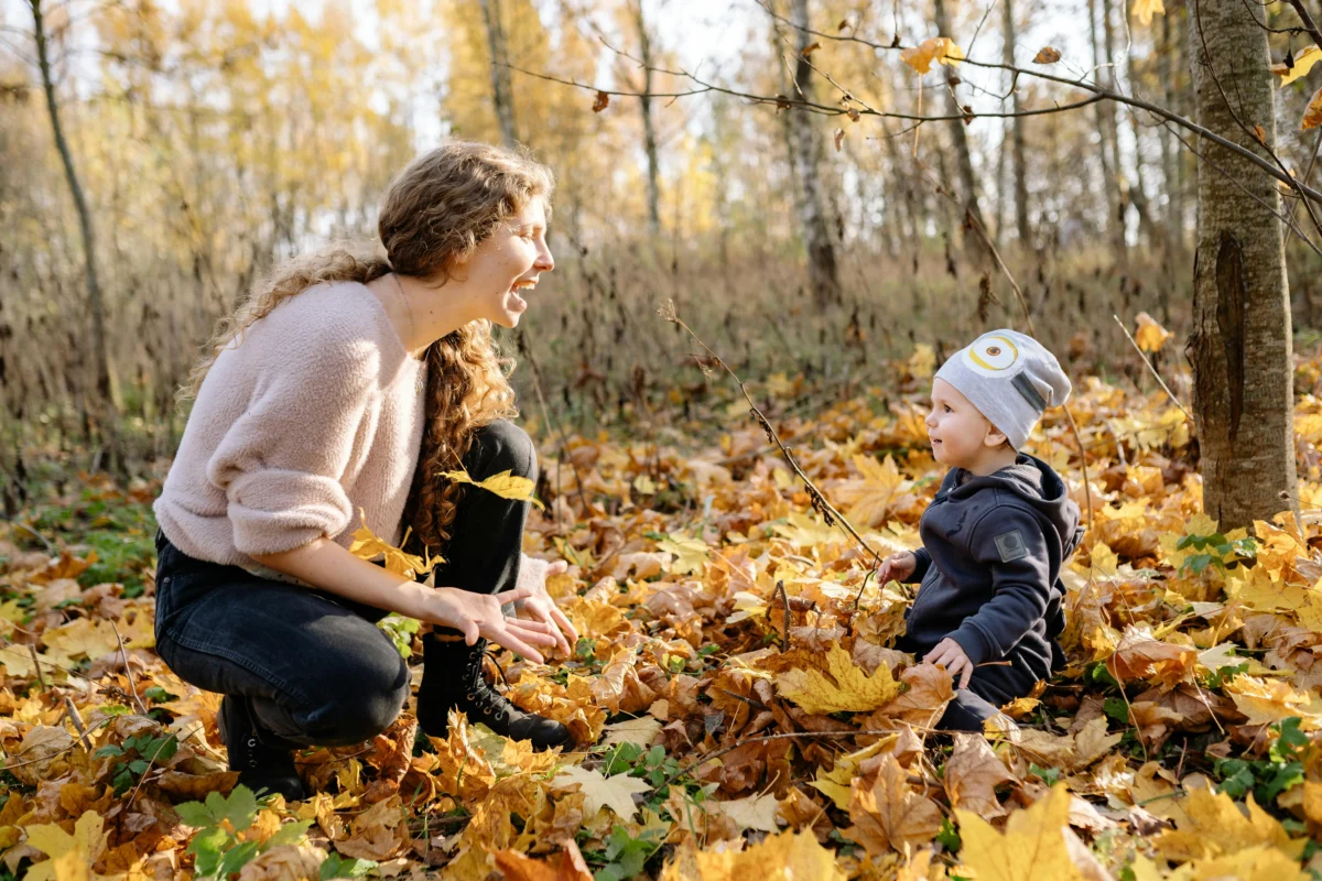 Una mamma aiuto il suo bambino a gestire le emozioni in un bosco d'autunno